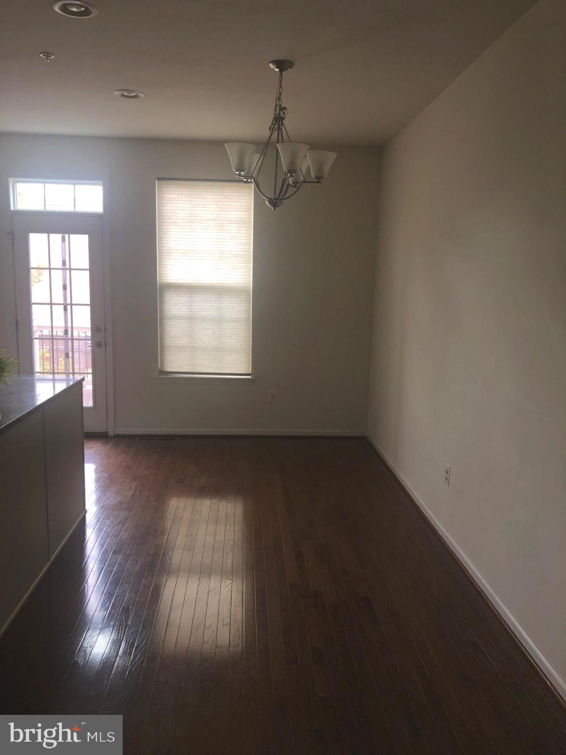 1728 Lantern Mews Baltimore, MD 21205 - Photo 5 of 16 an empty room with wooden floor and windows