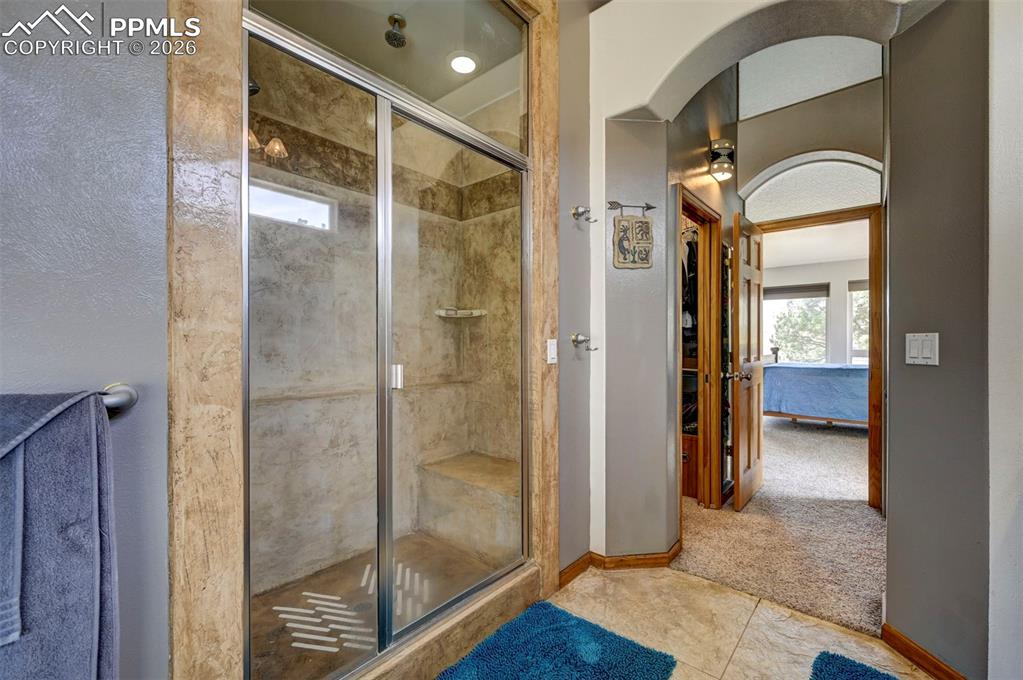 5910 McCart Ranch Circle Elizabeth, CO 80107 - Photo 16 of 50 a bathroom with a glass shower door and a mirror