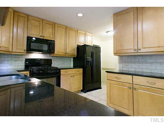107 Kings Fork Road Cary, NC 27511 - Photo 4 of 25 Updated kitchen: cabinets, granite counters, tile back splash, floor, lighting, gas range and other appliances.