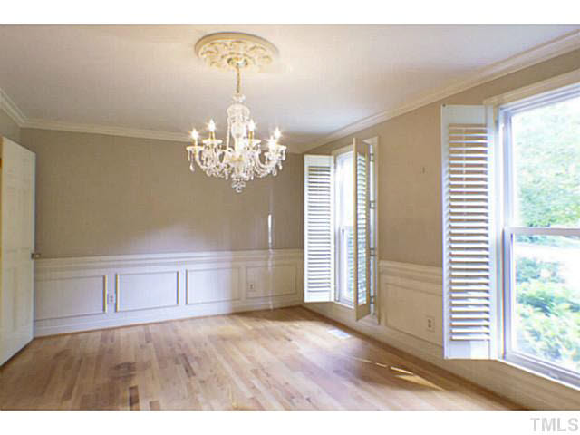 107 Kings Fork Road Cary, NC 27511 - Photo 6 of 25 Formal dining room, with beautiful chandelier, plantation shutters, crown molding wainscoting and hardwood floors.
