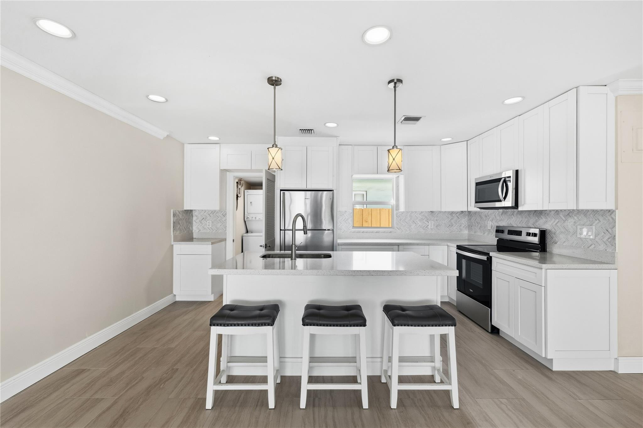 2000 Northeast 17th Street Fort Lauderdale, FL 33305 - Photo 13 of 44 a kitchen with white cabinets and stainless steel appliances