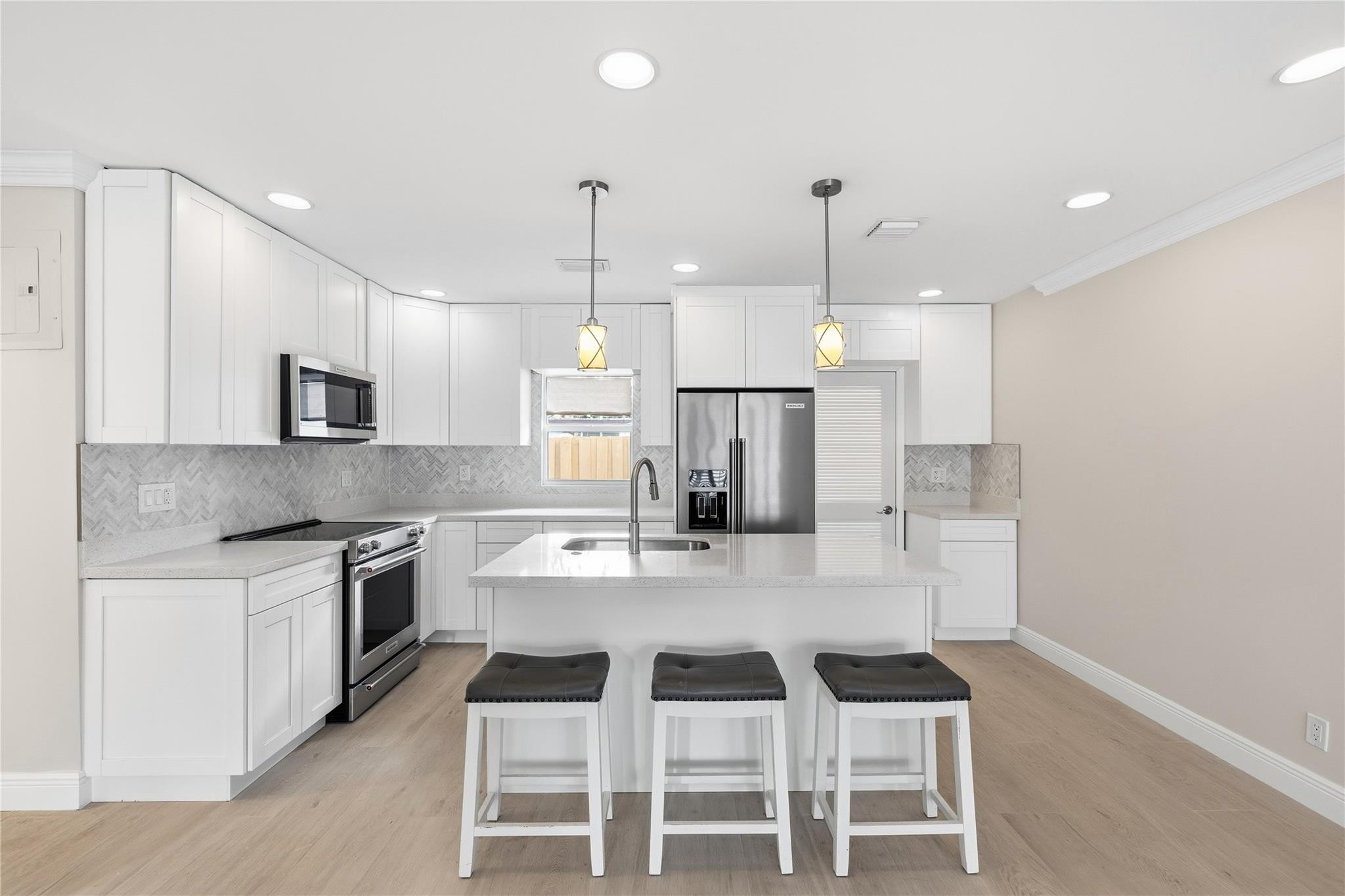 2000 Northeast 17th Street Fort Lauderdale, FL 33305 - Photo 25 of 44 a kitchen with kitchen island granite countertop a counter space stainless steel appliances and cabinets