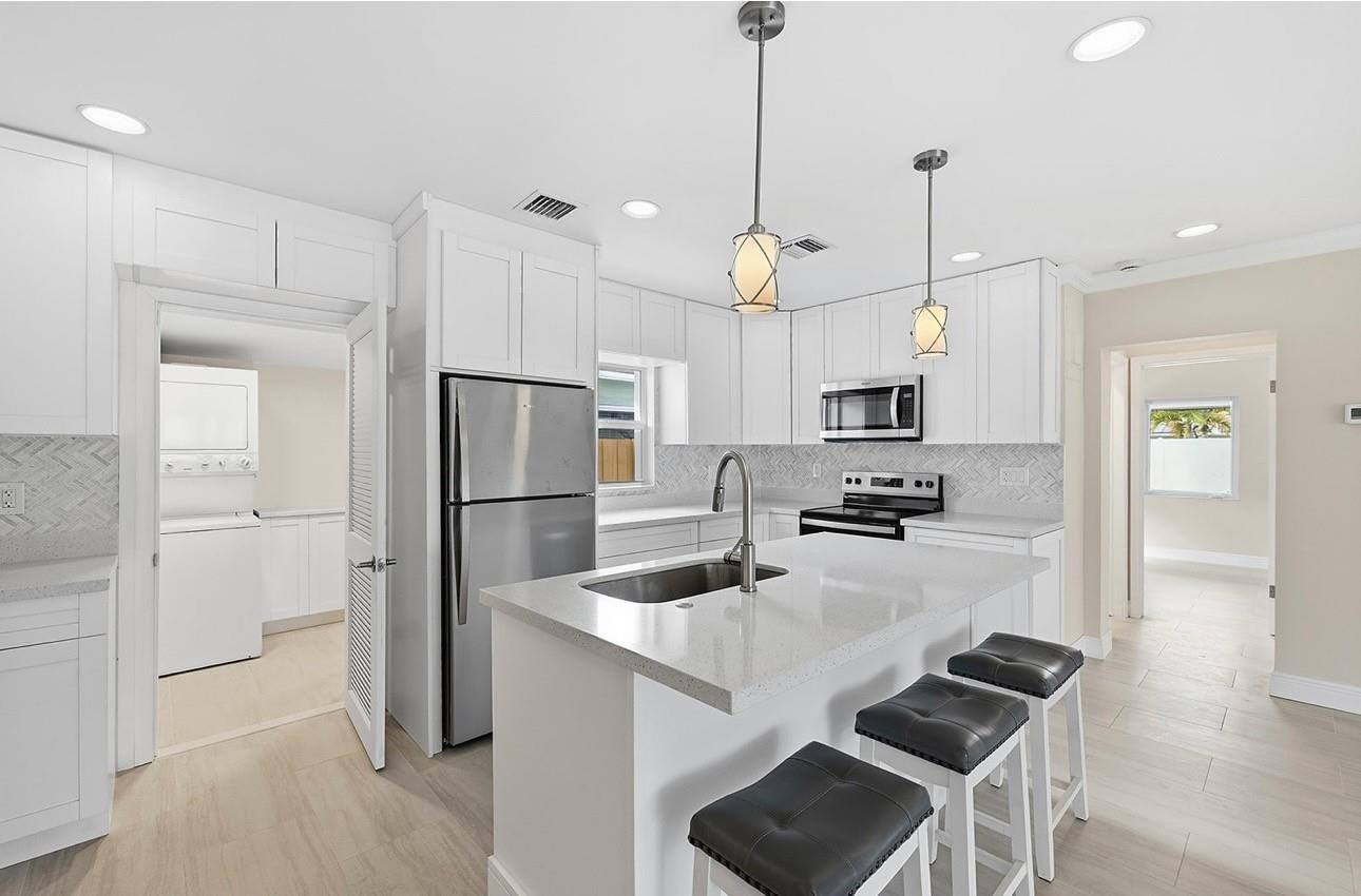 2000 Northeast 17th Street Fort Lauderdale, FL 33305 - Photo 35 of 44 a kitchen with stainless steel appliances granite countertop a refrigerator a sink a stove and white cabinets