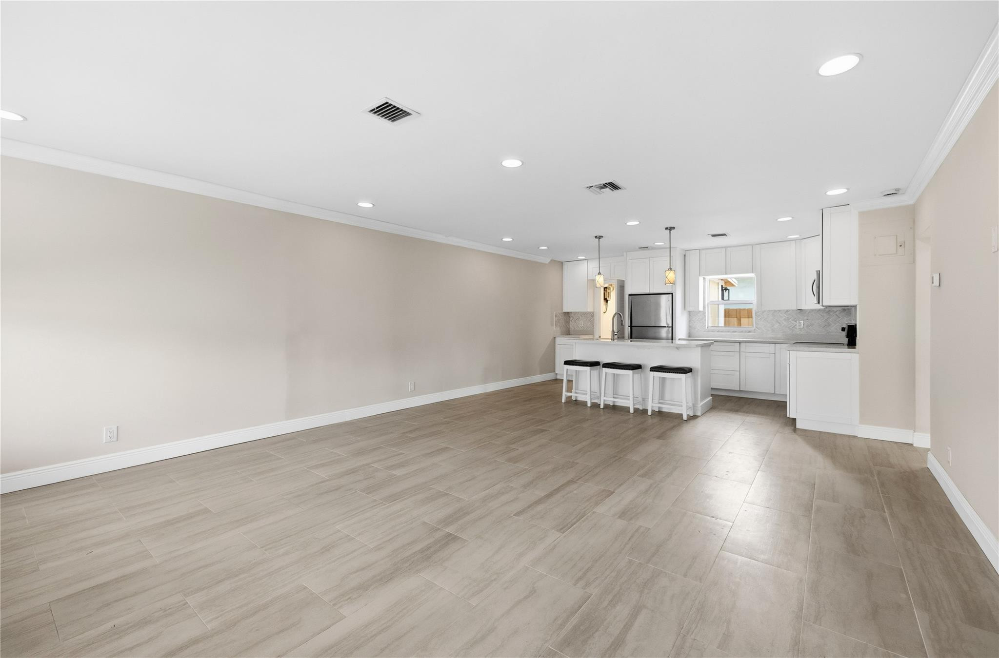 2000 Northeast 17th Street Fort Lauderdale, FL 33305 - Photo 9 of 44 a large white kitchen with wooden floors and white walls