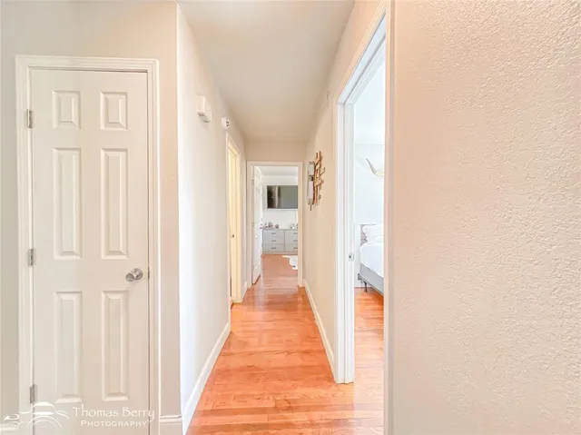 a view of a hallway with wooden floor and staircase