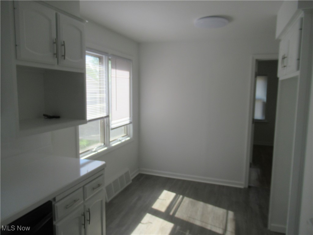 1397 Sunset Road Cleveland, OH 44124 - Photo 18 of 32 Unfurnished dining area featuring baseboards and dark wood-type flooring