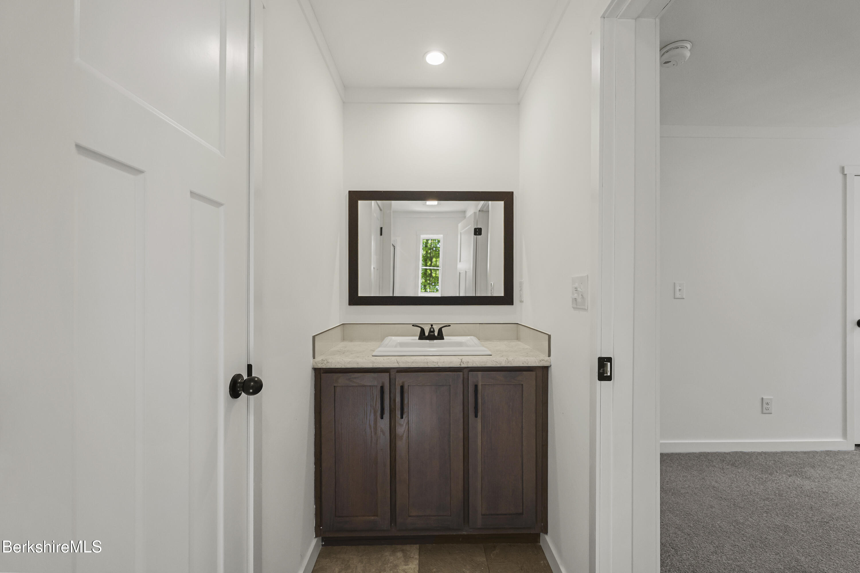 395 Cheshire Road, Unit 112 Pittsfield, MA 01201 - Photo 24 of 32 a bathroom with a sink and a mirror