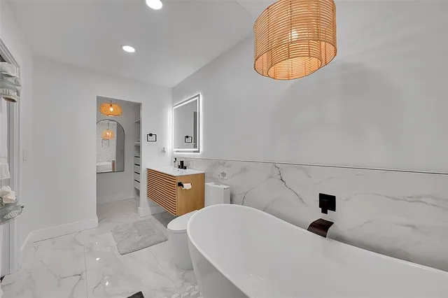 a bathroom with a sink a bathtub and a chandelier