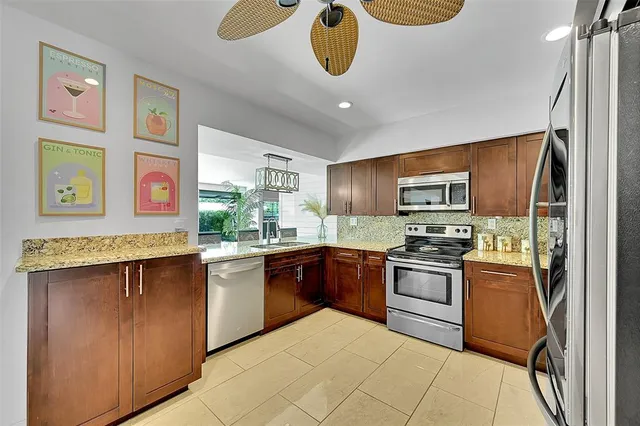a kitchen with stainless steel appliances granite countertop a stove top oven a sink dishwasher and cabinets with wooden floor