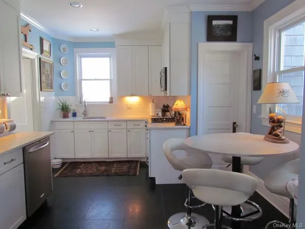 a kitchen with stainless steel appliances kitchen island granite countertop a sink cabinets and wooden floor
