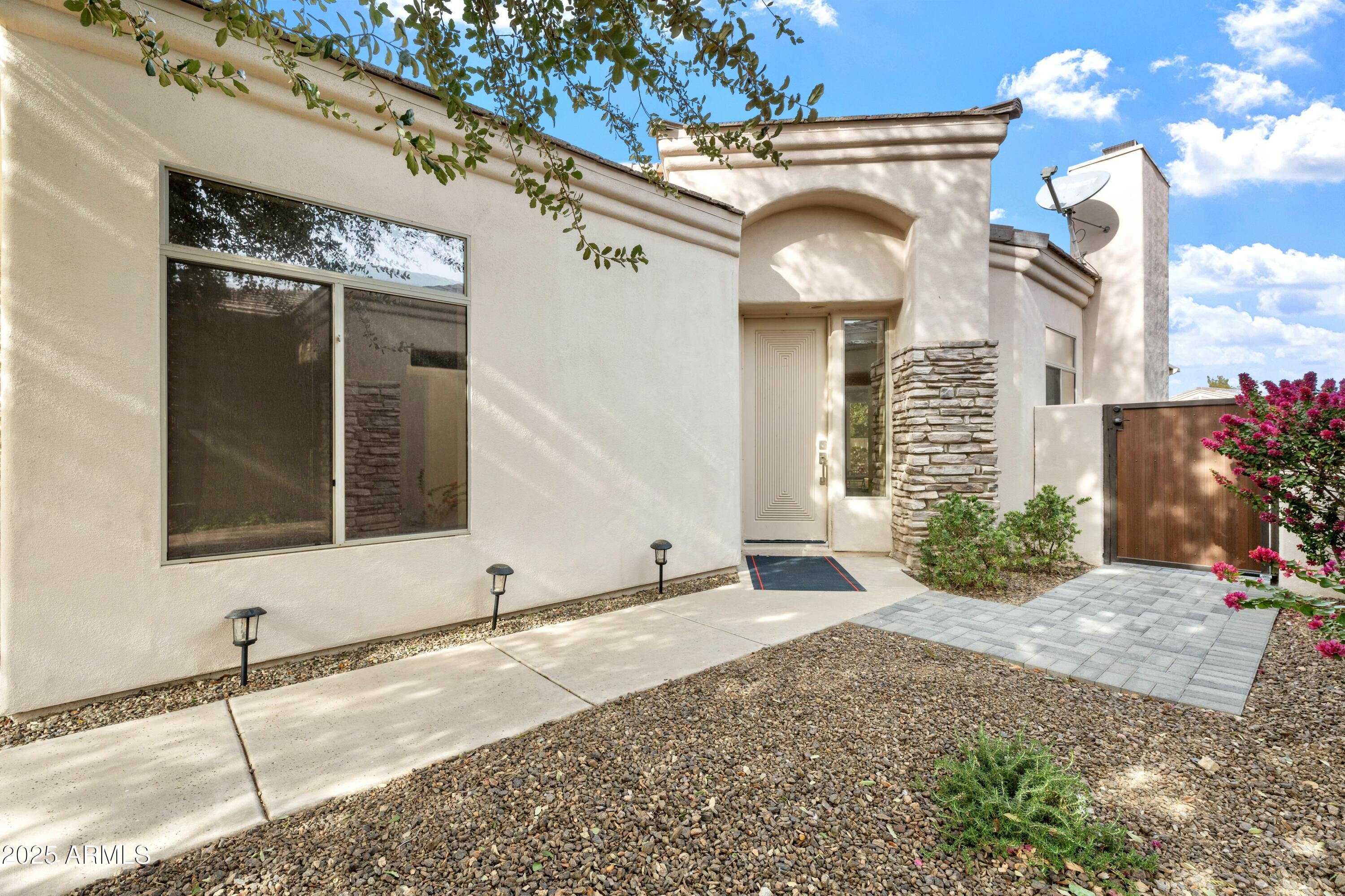 3830 East Carter Drive Phoenix, AZ 85042 - Photo 4 of 30 a view of a brick house with potted plants