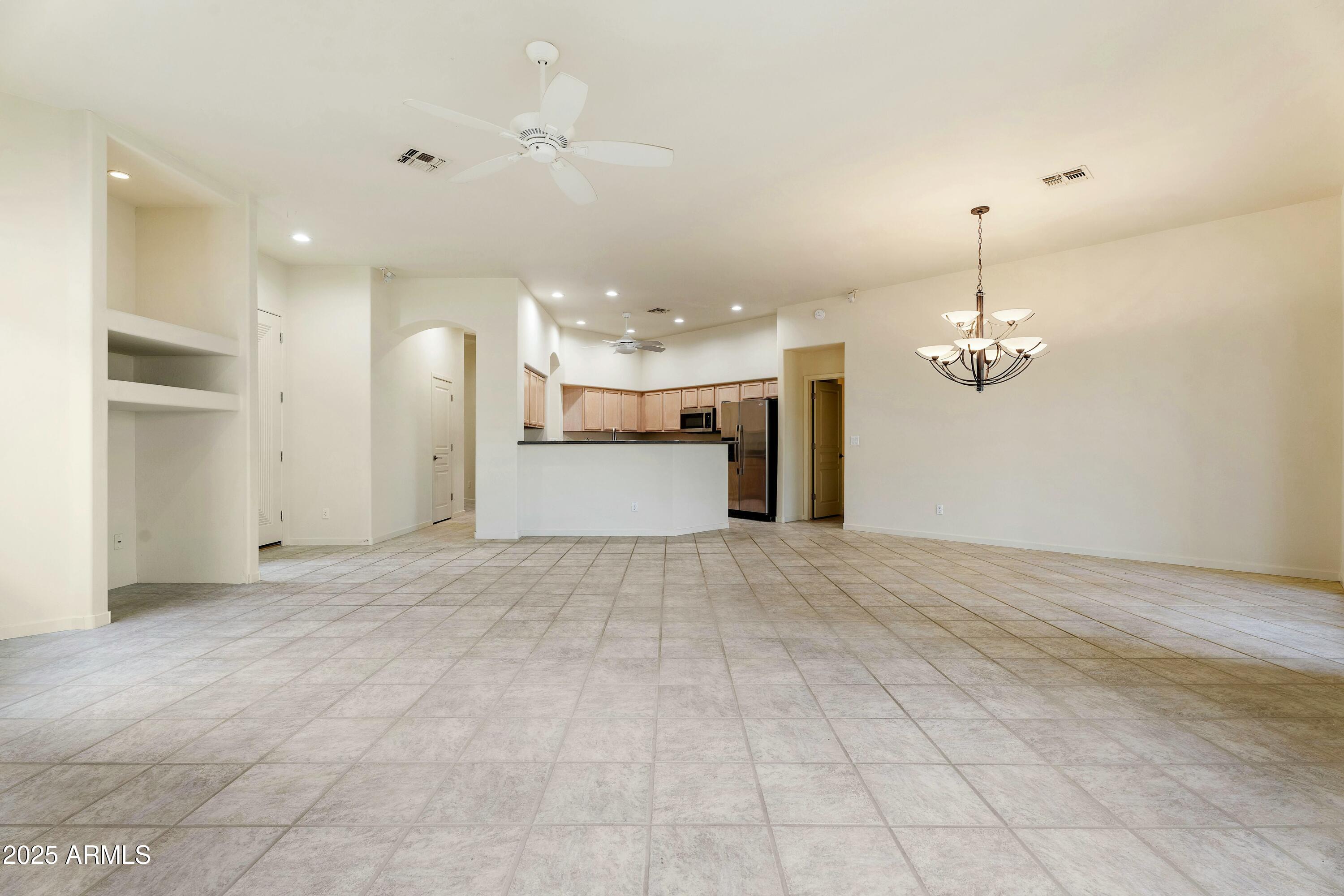 3830 East Carter Drive Phoenix, AZ 85042 - Photo 8 of 30 a view of a livingroom with a chandelier fan and kitchen view
