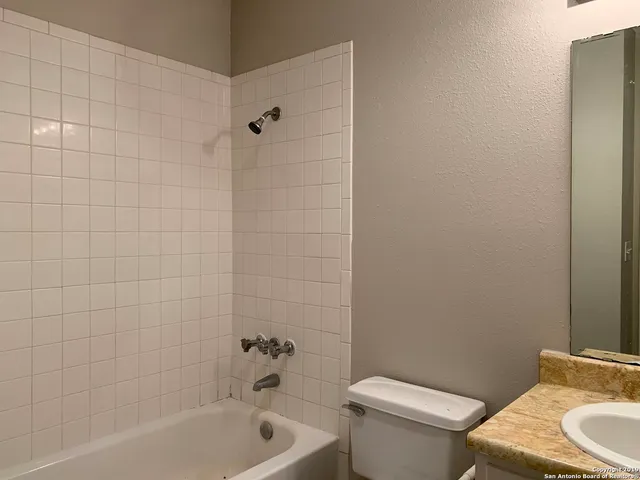 a white toilet sitting next to a bath tub