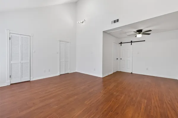 a view of an empty room with wooden floor