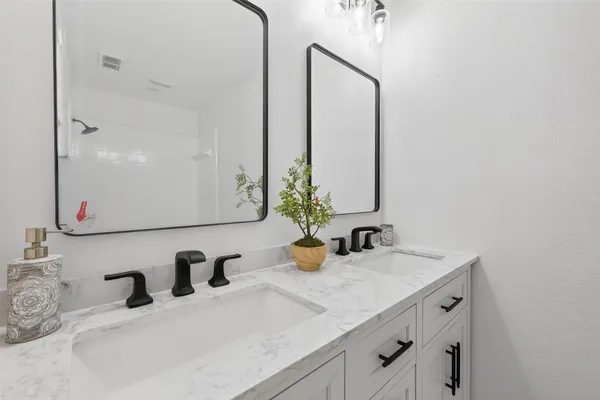 a bathroom with double vanity sinks and a mirror