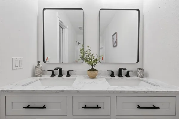 a bathroom with double vanity sinks and a mirror