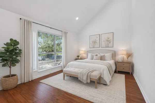a bedroom with a large bed and a potted plant