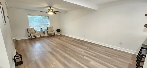 an empty room with windows and ceiling fan