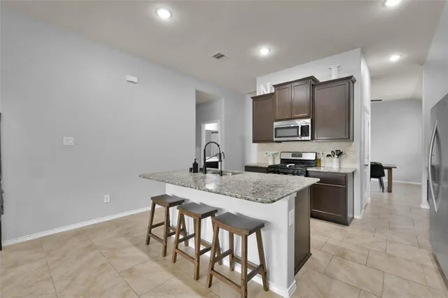 a kitchen with stainless steel appliances granite countertop a sink and cabinets