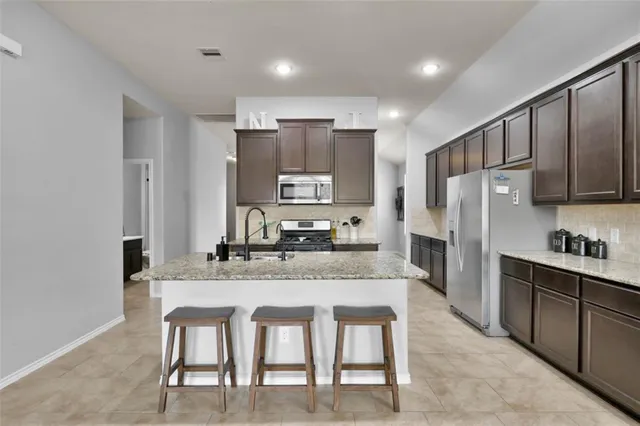 a kitchen with kitchen island a sink appliances and cabinets