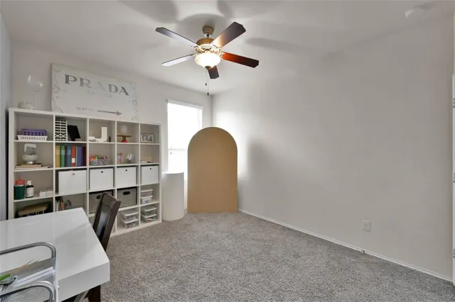 a living room with furniture and a ceiling fan