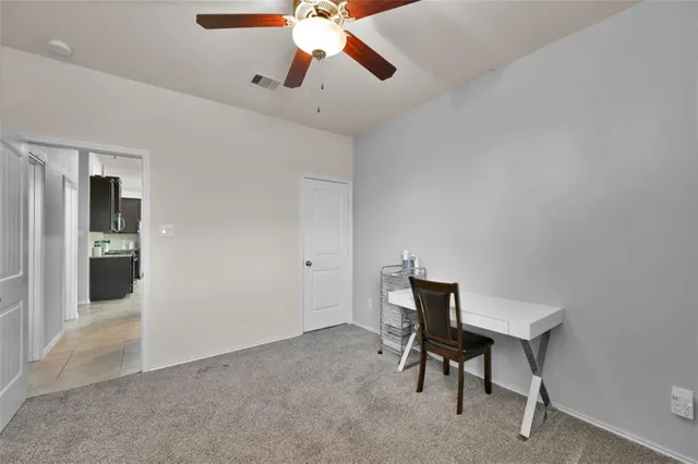 a view of a workspace with furniture and a window