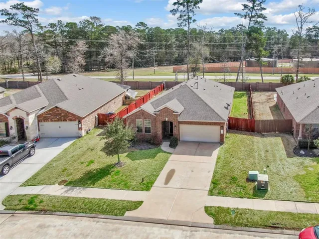 an aerial view of a house with a yard and large tree