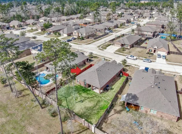 an aerial view of a house with a yard and lake
