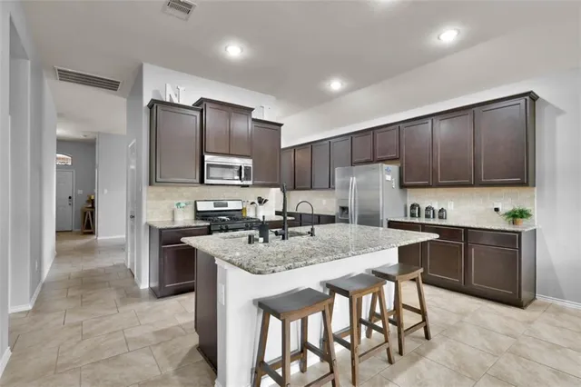 a kitchen with granite countertop stainless steel appliances and wooden cabinets