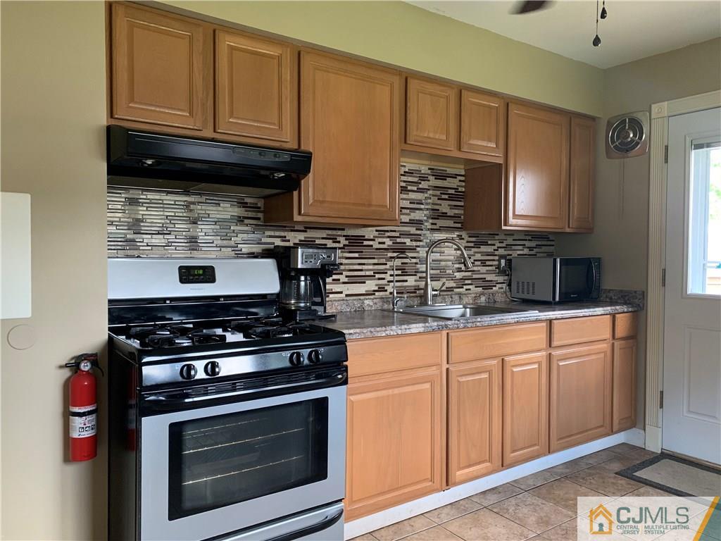 34 Windsor Road Edison, NJ 08817 - Photo 7 of 15 a kitchen with stainless steel appliances granite countertop a stove microwave and sink