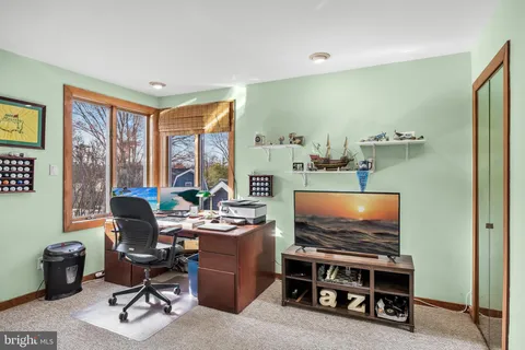 a living room with furniture a flat screen tv and a floor to ceiling window