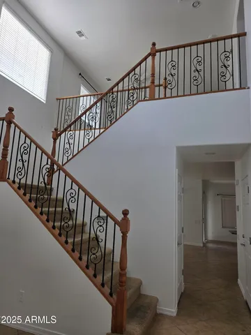 a view of staircase with lots of frames on wall and a window