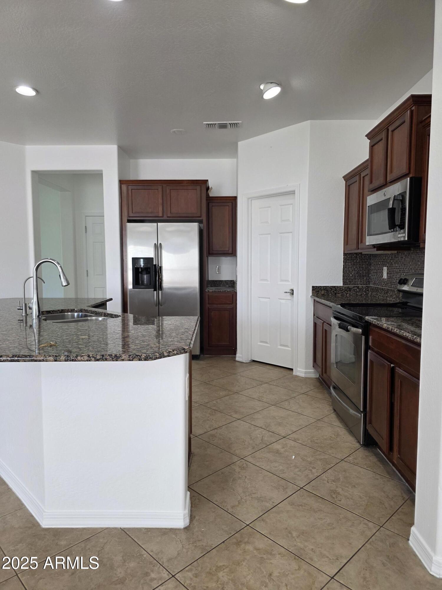 16206 North 22nd Lane Phoenix, AZ 85023 - Photo 8 of 29 a kitchen with stainless steel appliances granite countertop a stove a sink and a refrigerator