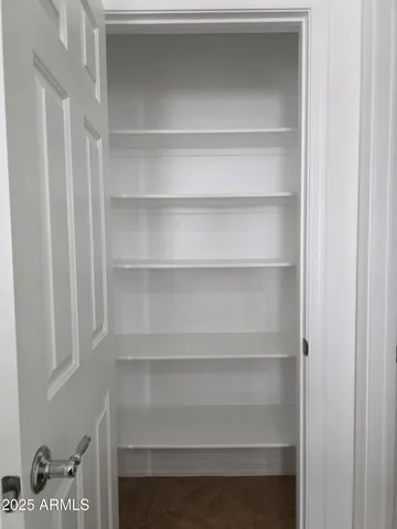 a view of walk in closet with empty racks