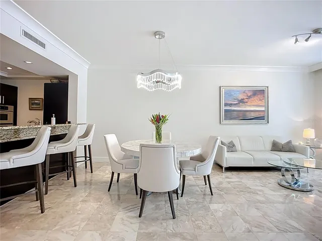 a living room with furniture a chandelier and a glass door