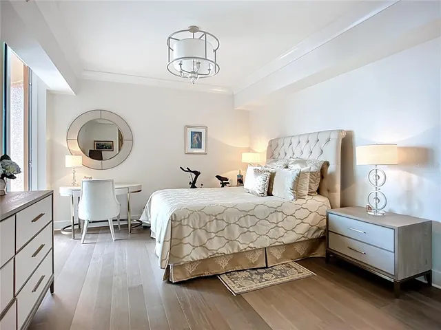 a bedroom with a bed and a lamp on dresser