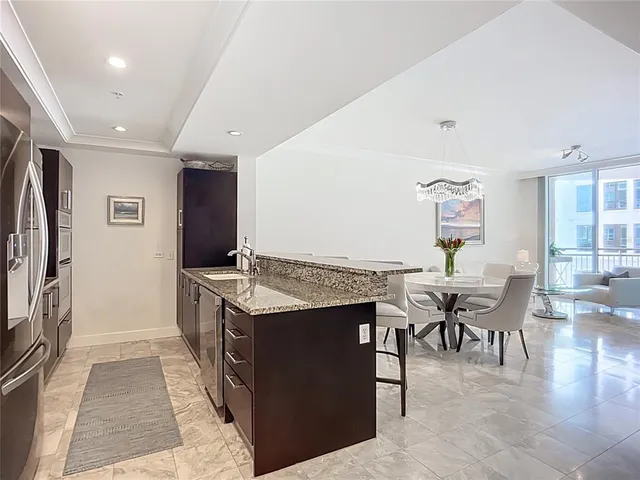 a kitchen with granite countertop a table and chairs in it