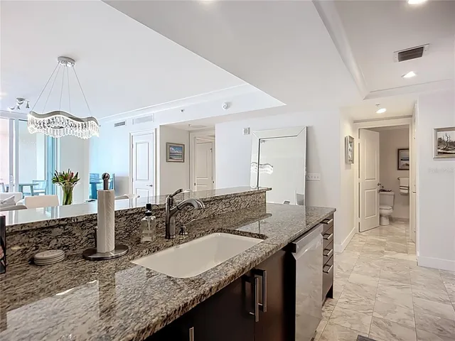 a bathroom with a granite countertop sink a mirror and shower