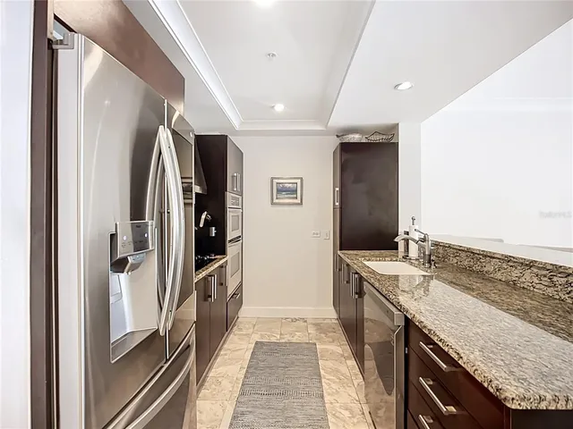 a bathroom with a granite countertop double vanity and a shower