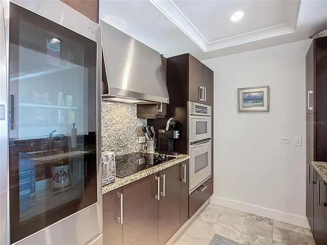 a kitchen with stainless steel appliances granite countertop a refrigerator and a stove