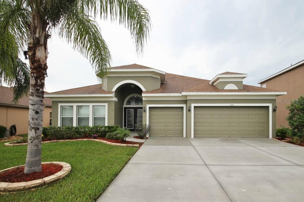 11244 Tayport Loop New Port Richey, FL 34654 - Photo 1 of 1 a front view of a house with a yard and garage