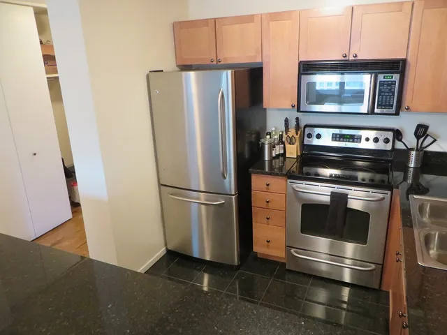 a kitchen with stainless steel appliances granite countertop a stove a microwave and a sink