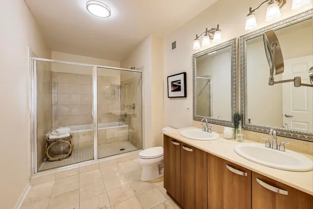 a bathroom with a granite countertop sink toilet and shower