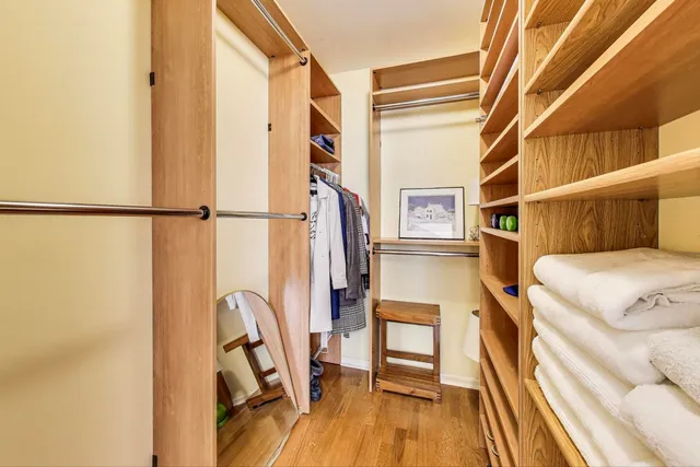 a view of walk in closet with clothes and shoes