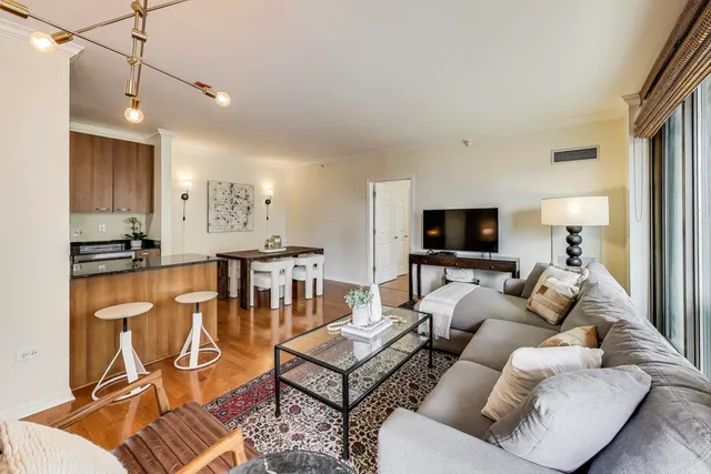 a living room with furniture kitchen view and a flat screen tv