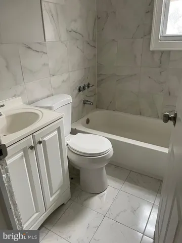 a white toilet sitting next to a bath tub