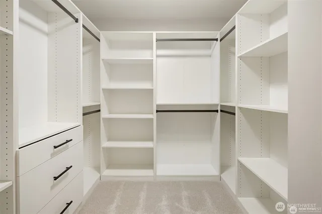 a view of walk in closet with empty racks