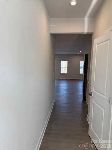 a view of a hallway with wooden floor and closet