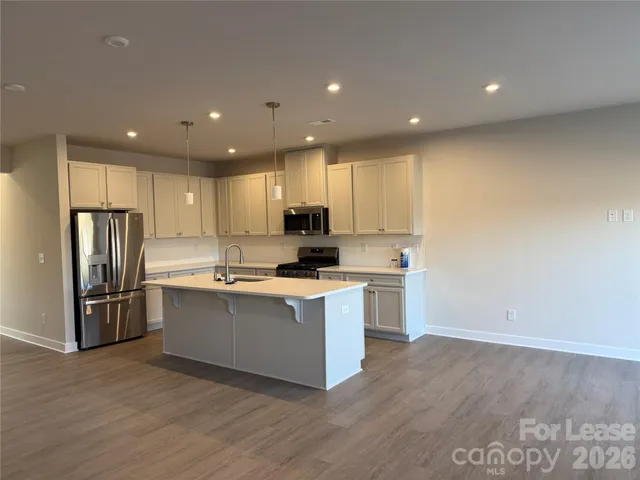 a kitchen with stainless steel appliances granite countertop a stove a refrigerator a sink and a oven