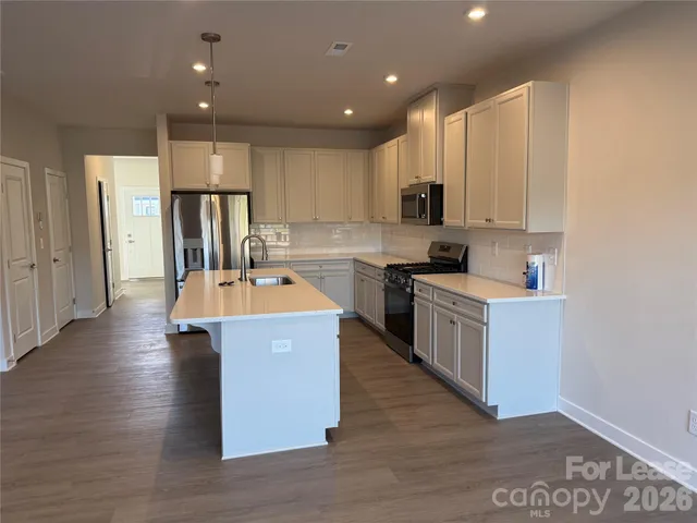 a kitchen with a sink a counter top space and stainless steel appliances